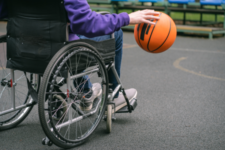 Jeune en fauteuil roulant jouant au basketball