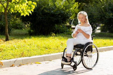 Jeune femme en fauteuil roulant consultant une application sur son téléphone